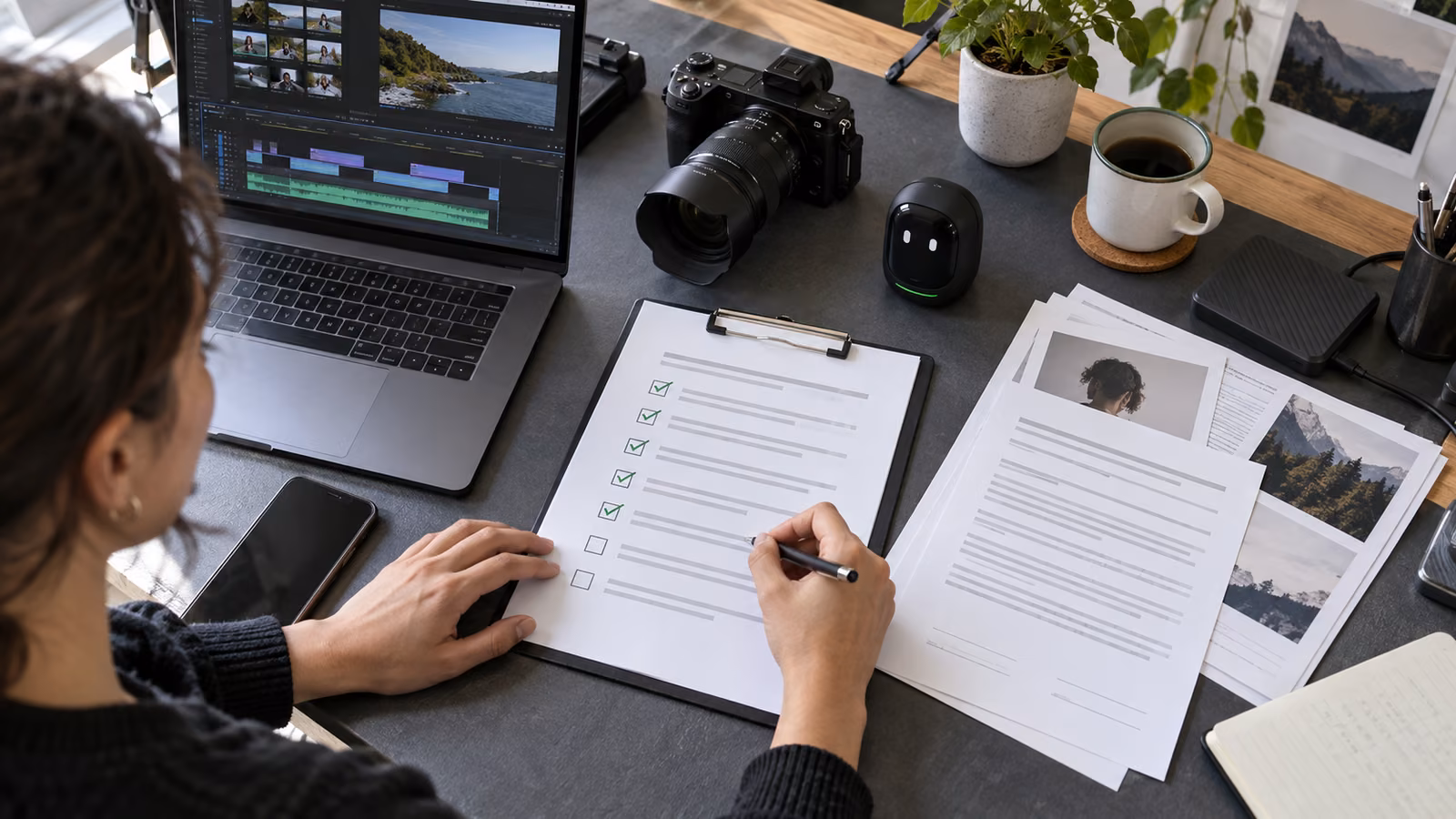 Video creator reviewing an AI content disclosure checklist beside a camera, editing laptop, and small black pocket AI companion