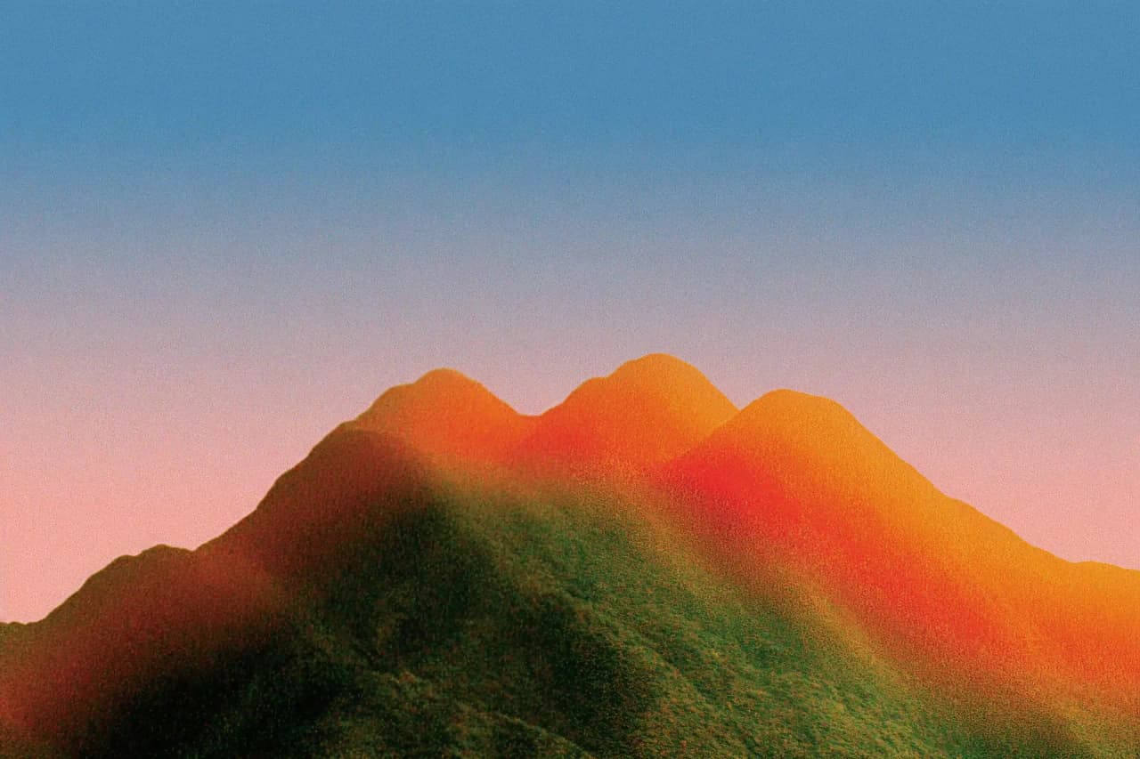 Abstract orange mountain peaks against a blue and pink sky